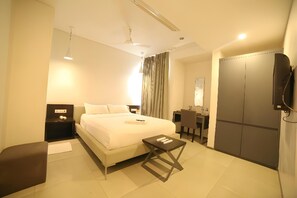 A hotel room with a bed, bedside table, chair, desk, and wardrobe. - M3 Boutique Hotel (Madurai)