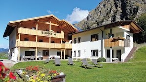 A two-story building with a wooden facade and balconies, labeled "BERGHEIM."