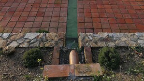 Une piscine avec une terrasse en briques et une vue sur une ville en arrière-plan.