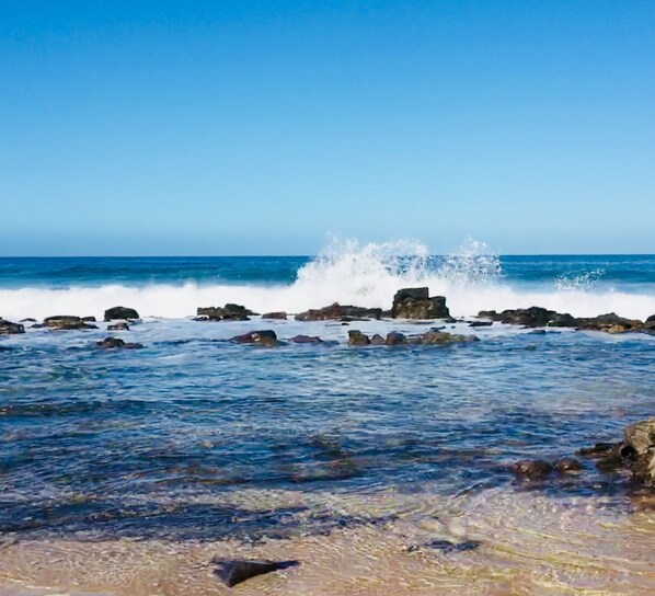 A rocky shoreline with waves crashing against the rocks.