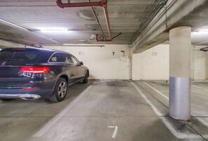 Un garaje de estacionamiento con un auto estacionado en un espacio marcado con el número 7.