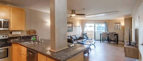 A modern kitchen with granite countertops, wooden cabinets, and stainless steel appliances.