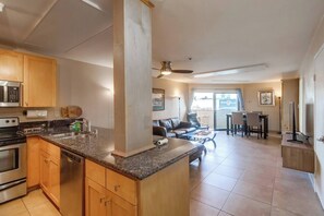 A modern kitchen with granite countertops, wooden cabinets, and stainless steel appliances.