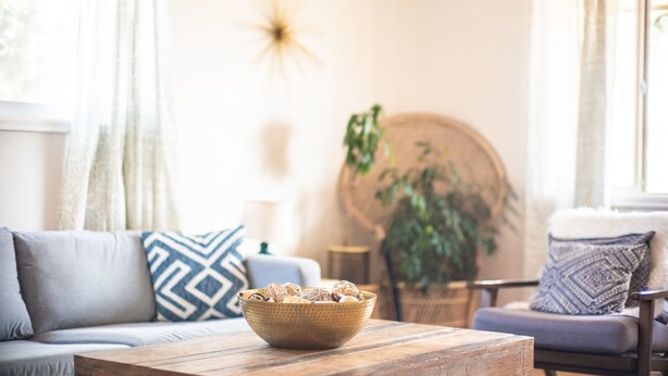 A cozy living room with a sofa, a coffee table with a woven basket, and a round wooden table. - Bright family friendly 3 bed 2 bath w/3 king beds located near AFA (Colorado Springs)