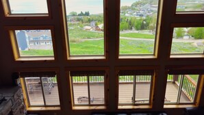 Una habitación con varias ventanas que dan a un barrio residencial y una masa de agua.