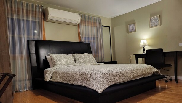 Een slaapkamer met een bed, een bureau en een stoel.