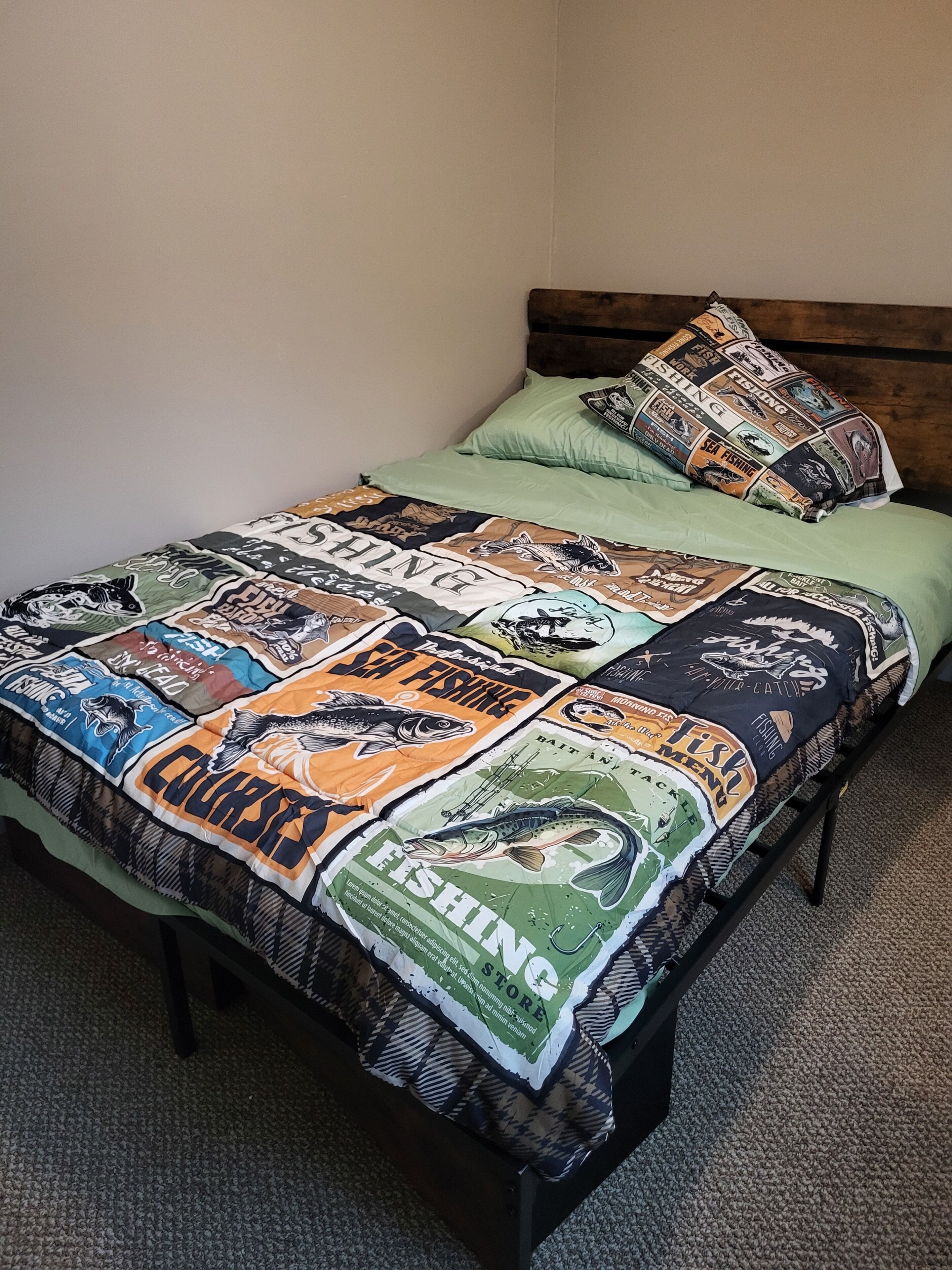 Un lit avec une couette à motifs de pêche, un oreiller vert et un autre oreiller assorti, également à motifs de pêche.