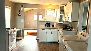 A kitchen with white cabinets, a stove, and a dishwasher.