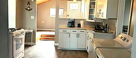 A kitchen with white cabinets, a stove, and a dishwasher.