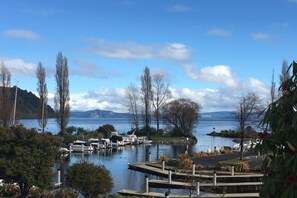 A marina with docked boats, surrounded by trees and a lake.