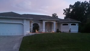 Ein Wohnhaus mit Auffahrt, Rasen und Garage.