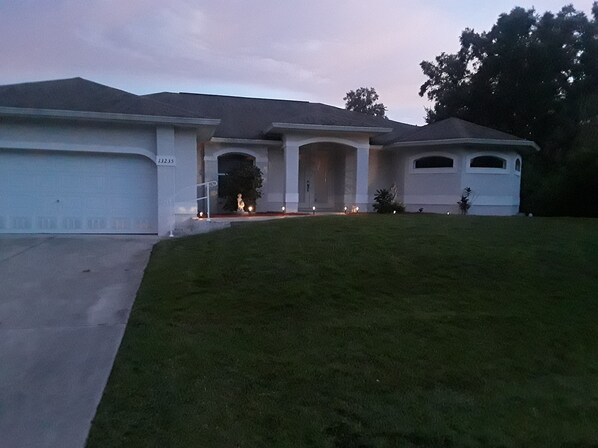 A residential house with a driveway, a lawn, and a garage.