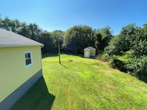 A residential property with a well-maintained lawn, a small shed, and a house with a visible window. - Central A/C, Secluded, Lots of space, Close to beach; 2 wks left for Summer '27 (Narragansett)