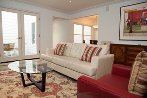 Relax in style with a sofa, armchair, and glass coffee table, perfect for socializing and unwinding.