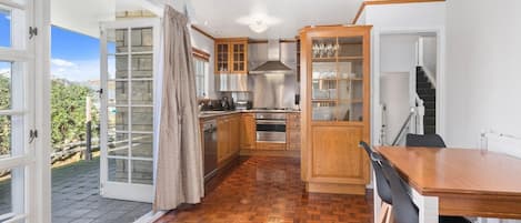 A kitchen with wooden cabinets, a dining table, and a view of the outdoors.
