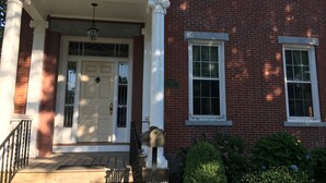 A two-story brick building with a white front porch and a door. - The coast of Maine a spacious 10 bedroom home. Equipped with an in ground pool (Saco)