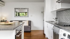 Eine moderne Küche mit eingebautem Geschirrspüler, einer grauen Arbeitsplatte und einer grauen Spritzschutzwand.