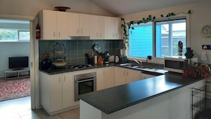 Una cocina moderna con armarios blancos, estufa a gas, un lavamanos y una ventana con vistas al exterior.