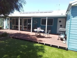 A house with a covered patio, a table with chairs, and a water dispenser. - Dare Beach House Escape | Ocean Grove | Perfect for a family getaway (Ocean Grove)