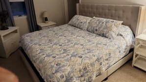 A bedroom with a bed, a nightstand, a dresser, a window with curtains, and a closet. - Oak Bluffs - Quiet neighborhood (Oak Bluffs)