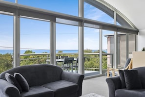 A balcony with a view of the sea, furnished with two sofas and a table. - Magnum (Lorne)