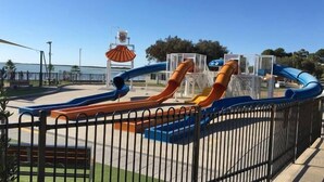 Un parc infantil amb diverses tobogans i una zona tancada.