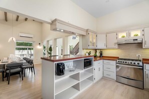 A modern kitchen with white cabinetry, a stainless steel stove, and a built-in oven.
