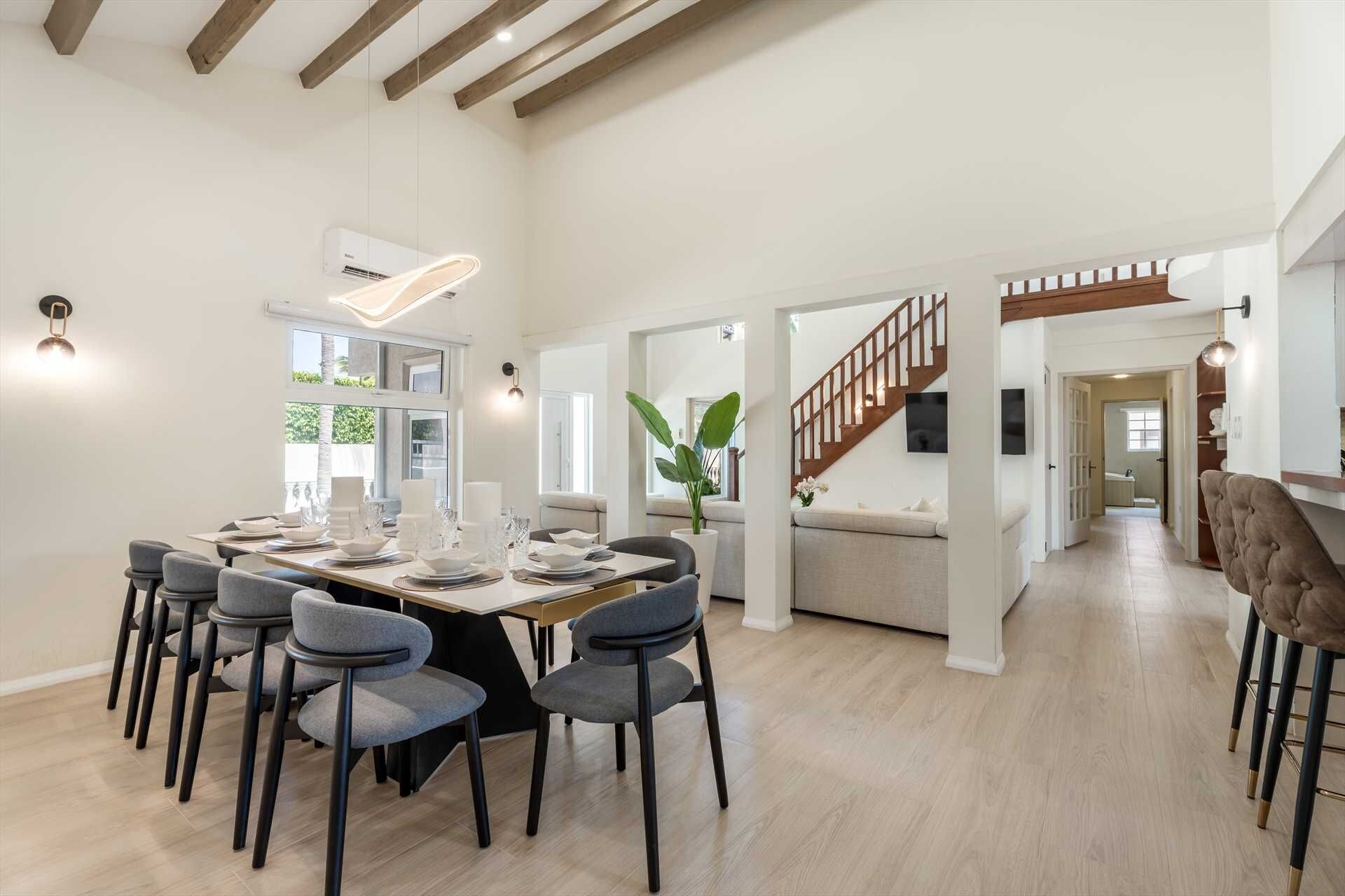 Un comedor espacioso con techo alto, una escalera y vistas al exterior.