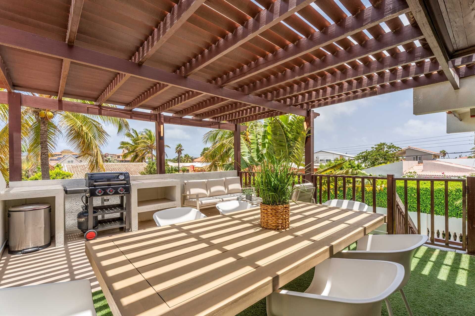 Un patio exterior con una pérgola de madera, una parrilla, una mesa de comedor con sillas y una planta en maceta.