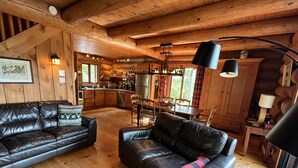 Interior acogedor de una cabaña con techo de madera, comedor y cocina.