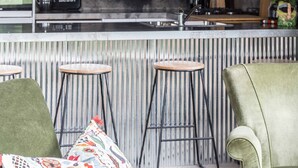 A bar area with three stools and a green armchair. - WATERSHED Robertson - a chic shed conversion (Robertson)