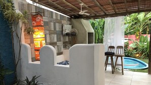 A patio area with a pool, outdoor seating, and a decorative wall.