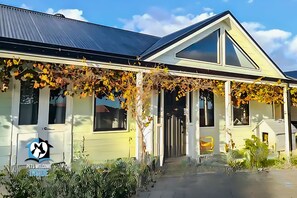 A yellow building with a covered porch and a large window. - A Beautiful  Property, Walking Distance to the Beach in Esperance WA! (West Beach)
