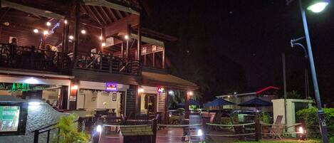 A two-story building with a balcony and outdoor seating area.