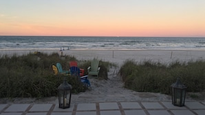 A beach view with a pathway leading to beach chairs and lanterns. - 4 Bdrm/3 Bath The Tatum House Cottage - Direct Oceanfront (New Smyrna Beach)
