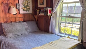 Um quarto aconchegante com uma cama, um abajur e uma janela com cortinas.