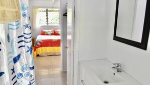 A bathroom with a white sink and a mirror. - Rona Kaitangata - across the road from the beach (Muri Beach)