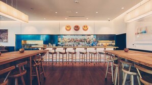Un bar moderno con arredi in legno e un bancone centrale.