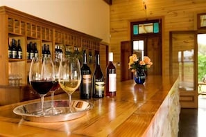 Um balcão de madeira com garrafas de vinho e copos.