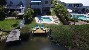 A residential area with multiple houses, a swimming pool, and a dock. - 1 Block to Beach on Private Lake Heated Pool, SPA  6937 Holmes Blvd. (Holmes Beach)