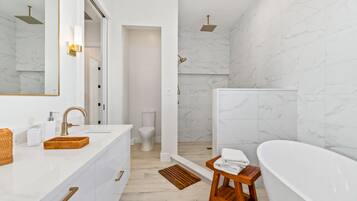 Bathtub, rainfall showerhead, hair dryer, towels