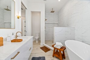 Bathtub, rainfall showerhead, hair dryer, towels