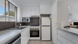 Cocina compacta equipada con microondas, horno y refrigerador.