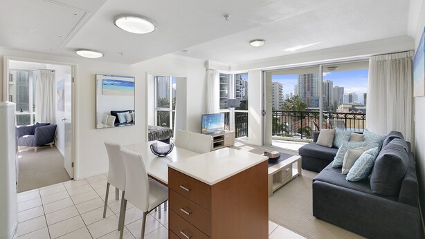 Ein modernes Wohnzimmer mit Schreibtisch, Sofa und großen Fenstern mit Blick auf die Stadt.