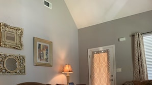 A living room with a brown leather sofa, a patterned rug, and a lamp.