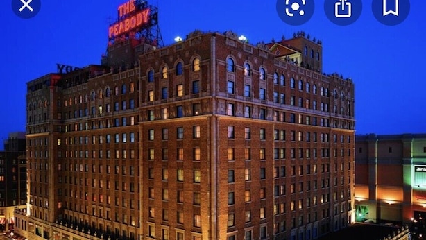 A multi-story building with a prominent sign at the top reading "THE PEABODY."
