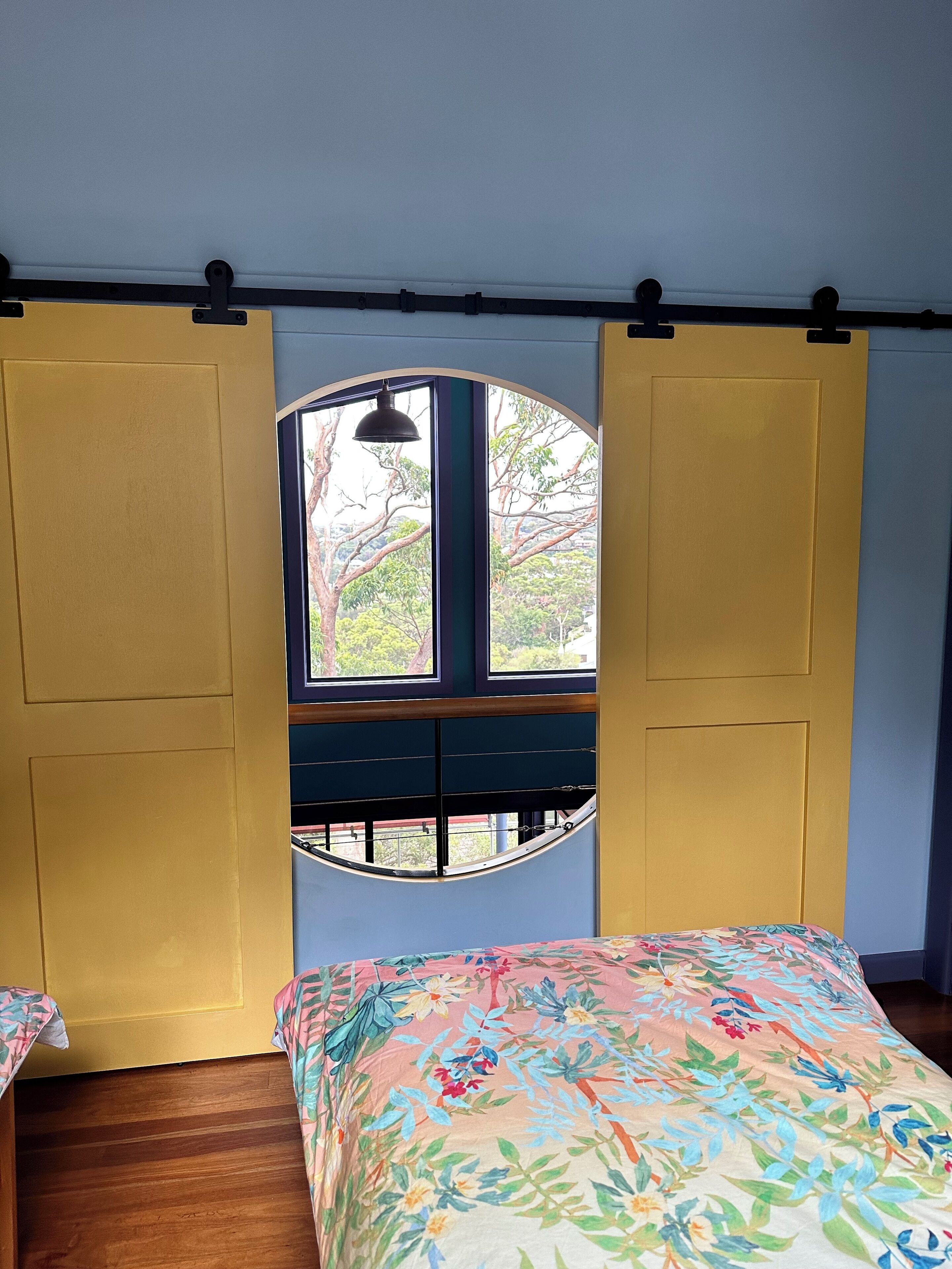 Een kamer met een bed, een raam en een deur.