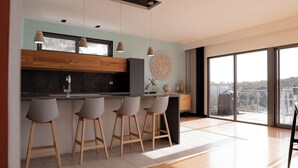 Una cocina moderna con barra, ventanas amplias y vistas a la ciudad.