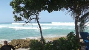 A beach scene with waves, a rocky shoreline, and a person in the foreground. - Room with a View! Stay LOVE PLAY on the beach in Isabela, between Jobos & Shacks (Isabela)