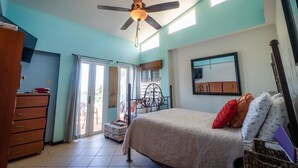 A bedroom with a bed, a dresser, a ceiling fan, and a window. - Room with a View! Stay LOVE PLAY on the beach in Isabela, between Jobos & Shacks (Isabela)